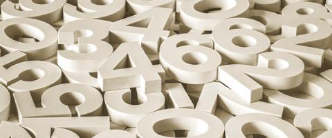 A scattered pile of large white 3D numbers overlapping one another.